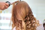 Femme ayant les cheveux enroulés avec un fer à friser