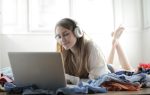 Femme avec casque écoutant de la musique devant un ordinateur portable
