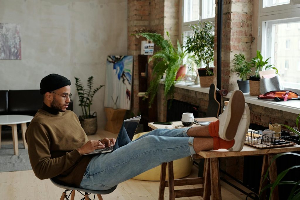 Homme avec un ordinateur portable, les pieds sur table